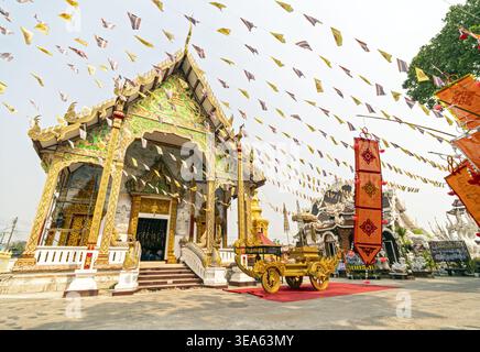 Dok kham tai, Phayao, Thailandia - 20 aprile 2026: Phra Chao Than Chai con elaborate finiture dorate sul tetto, dettagli esterni in verde e oro Foto Stock