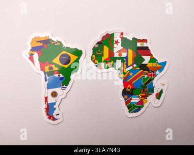 Due adesivi a forma di continenti del Sud America e dell'Africa, ciascuno riempito con le bandiere colorate delle rispettive nazioni. Foto Stock