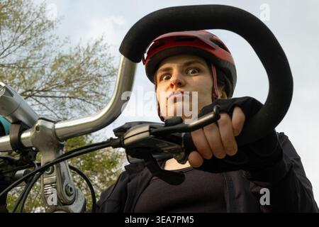 Ritratto di una ciclista divertente in un casco da vicino Foto Stock