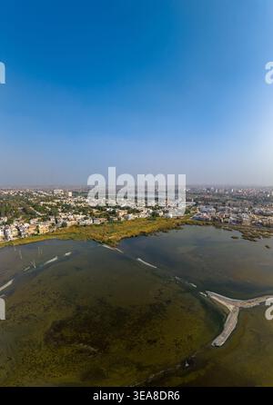 Vista aerea del paesaggio urbano e delle zone umide con fitti edifici residenziali sotto un cielo azzurro a Hyderabad, Sindh, Pakistan. Foto Stock