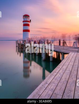Faro di Podersdorf e molo in legno al tramonto sul lago Neusiedl, Austria. Foto Stock