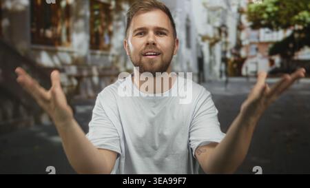 Uomo con mani aperte che gestisce in camicia bianca su strada con edifici e alberi sfocati; riflessi riflessi ponderati. Foto Stock