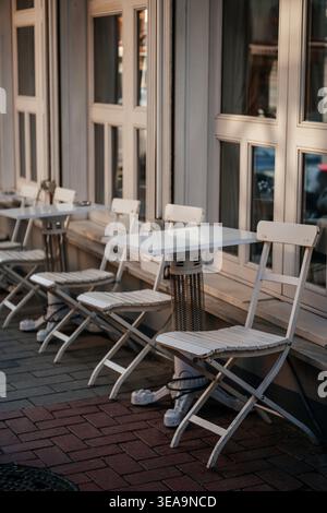 La scena mostra l'armoniosa disposizione di mobili bianchi sulla tranquilla terrazza urbana Foto Stock