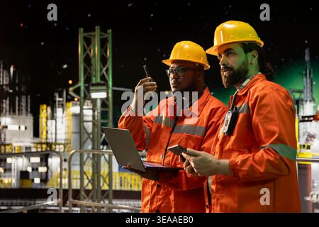 Brainstorming del team della piattaforma marittima offshore dopo aver analizzato l'efficienza della produzione durante le 24 ore di funzionamento. Colleghi di lavoro di squadra per chiatte che configurano i sistemi di gestione delle navi a tarda notte Foto Stock