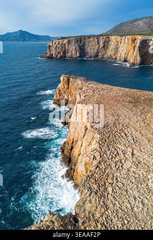 Veduta aerea verticale delle ripide scogliere calcaree e del blu profondo del Mediterraneo a Cala domestica, Sardegna, Italia Foto Stock
