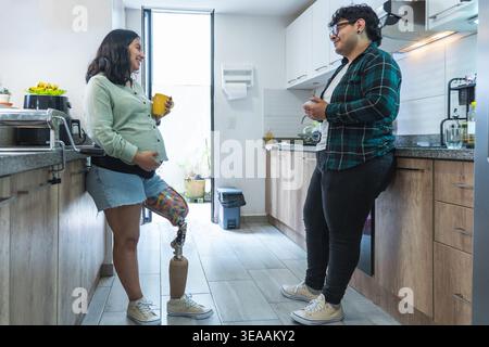 Aspettarsi una coppia in cucina, fare una conversazione e bere un caffè Foto Stock