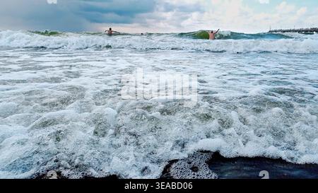 Mar Baltico in estate. Persone che nuotano tra le onde. Foto Stock