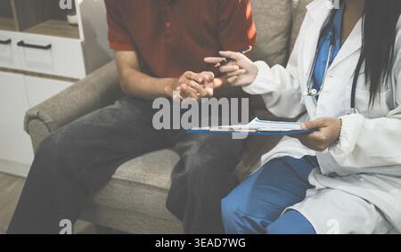 Operatore sanitario che fornisce supporto e assistenza empatica, mettendo delicatamente le mani sul braccio di una donna anziana Foto Stock