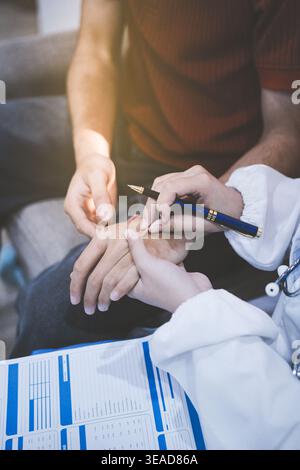Operatore sanitario che fornisce supporto e assistenza empatica, mettendo delicatamente le mani sul braccio di una donna anziana Foto Stock