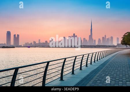 12 gennaio 2026, Dubai, Emirati Arabi Uniti: Paesaggio urbano con il Burj Khalifa e vari grattacieli da una tranquilla passeggiata sul lungomare al tramonto Foto Stock