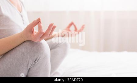 Mani di una donna anziana che pratica meditazione yoga Foto Stock