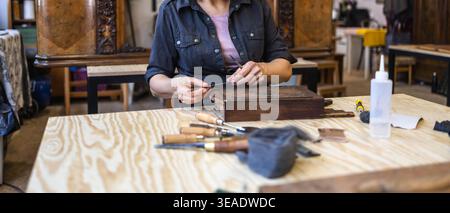 Restaurare la scatola in legno decorata con utensili manuali sul banco di lavoro Foto Stock