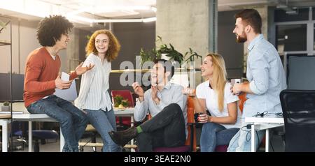 Diversi popolo millenario avente buona parlare a coworking space Foto Stock