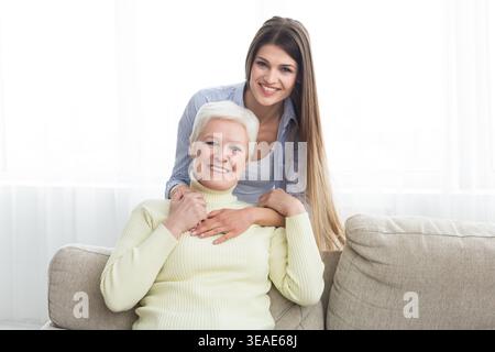 Ti amo mamma. Giovane donna abbracciando coppia madre Foto Stock