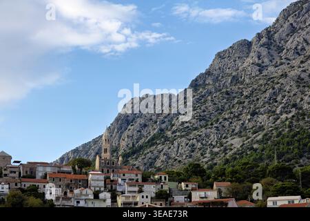 Centro di Igrane con vista sulla Torre Zale e le montagne sullo sfondo a fine estate, Croazia Foto Stock