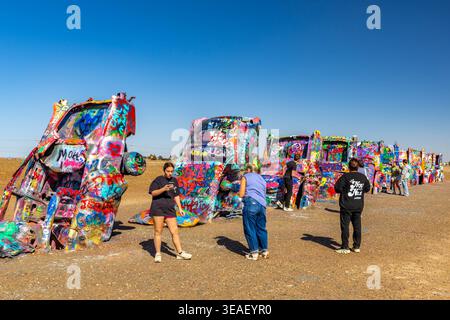 Amarillo, Texas, USA - 8 marzo 2026: Visitatori che visitano e dipingono auto al Cadillac Ranch lungo la Route 66 vicino ad Amarillo Texas Foto Stock