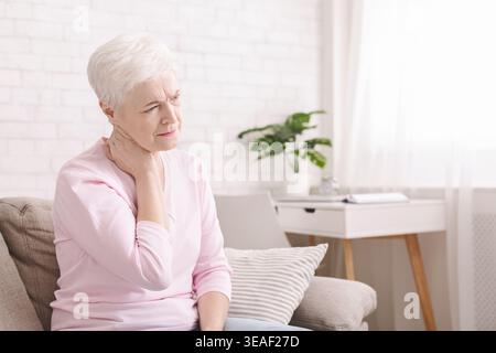 Donna matura che soffre di mal di schiena a casa Foto Stock