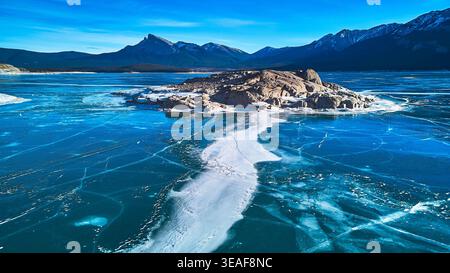 Il lago Abraham, ghiacciato dall'alto, affioramento roccioso e le montagne invernali, Alberta Foto Stock