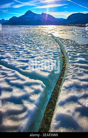 Frozen Lake Ice Crack Winter Mountain Landscape sotto la luce del sole Foto Stock