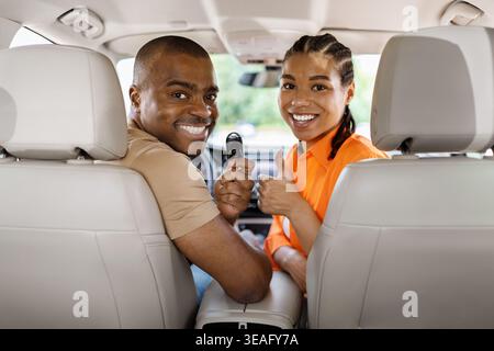Felice giovane coppia afroamericana che mostra la chiave dell'auto all'interno del veicolo Foto Stock