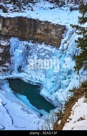 Cascata e scogliere ghiacciate con neve e piscina ghiacciata nella riserva naturale invernale Foto Stock