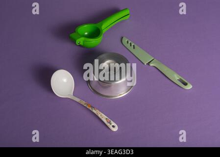 STILL Life mostra come cucinare attrezzi per spremiagrumi, coltelli, formelle per torte e stoviglie a cucchiaio. Riprese in studio, illuminazione controllata. Uso commerciale per la cottura Foto Stock