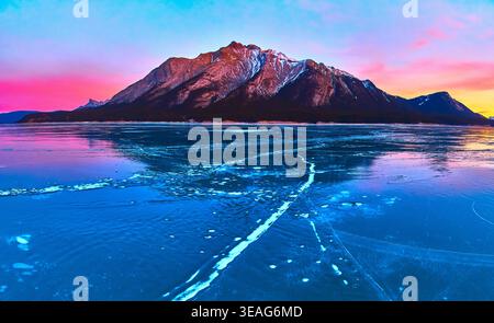 Panorama Frozen Lake with Cracked Ice e Mountain Sunset Reflection Winter Foto Stock