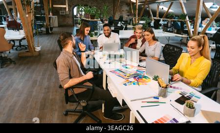 Giovani designer che discutono di un nuovo progetto in ufficio Foto Stock