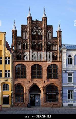 Facciata anteriore del Wulflamhaus, uno storico edificio in mattoni a tetto spiovente a Stralsund, Germania, caratterizzato da architettura gotica, dettagli ornati e torreggianti Foto Stock