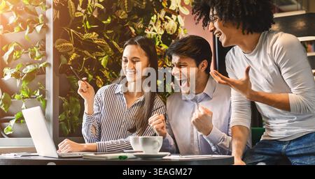 Collegio multietnica gruppo celebrare aggiudicarsi il successo in cafe Foto Stock