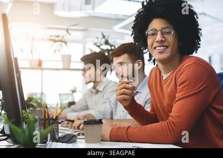 Allegro African American guy sorridente in telecamera a coworking Foto Stock