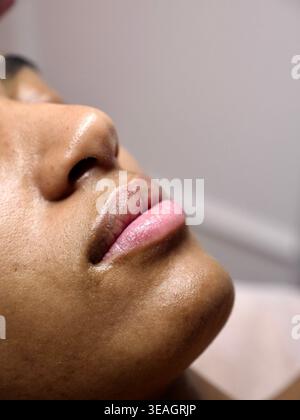 Donna nera godendo trattamento maschera come terapia. Concentrarsi sulla salute mentale, il benessere e il rituale di auto-cura durante la celebrazione del mese della storia nera. Foto Stock