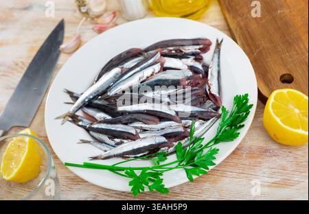 Un mucchio di pesce crudo piccolo è accatastato sul piatto, pronto per la frittura. Foto Stock