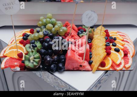 Vassoio di frutta vivace. Vivace raccolta di frutta fresca preparata su un piatto bianco. Una presentazione energica e colorata che mostra Array of Ripened Foto Stock