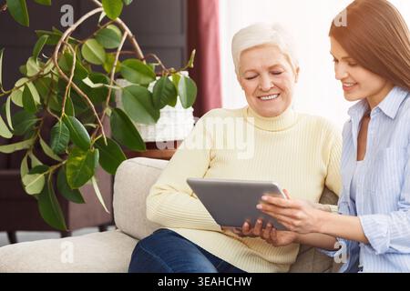 Madre e figlia senior navigano su Internet su tablet Foto Stock