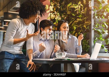 Collegio multietnica gruppo celebrare aggiudicarsi il successo in cafe Foto Stock