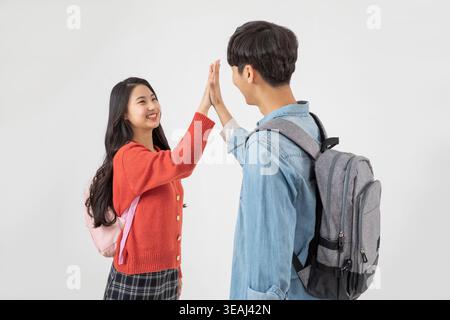 Due studenti delle scuole superiori, un ragazzo e una ragazza, si stanno allenando a vicenda in un'aula luminosa e moderna. Foto Stock