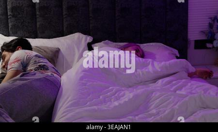 Giovane coppia che dorme insieme in un comodo letto di notte Foto Stock