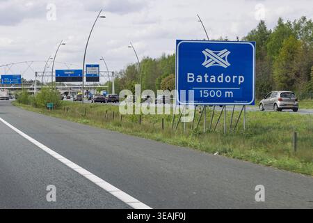Eindhoven, Paesi Bassi - 17 aprile 2026: Cartello blu che indica lo svincolo autostradale di Batadorp con il traffico sulle strade A2 e A58. Foto Stock