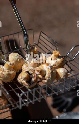 Primo piano dettagliato di funghi bianchi freschi in un cestello grill in metallo. Consistenza naturale di alimenti biologici per il design culinario. Foto Stock