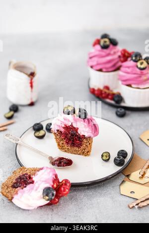 Elegante brunch con Cupcake decorati con frutti di bosco ed elementi con rivestimento leggero Foto Stock