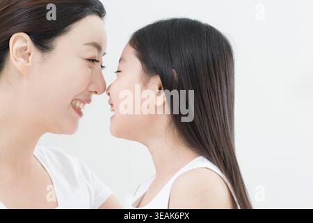 Vista laterale ritratto di sorridente madre e figlia faccia a faccia Foto Stock