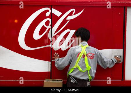 Osaka, Giappone. 23 aprile 2026. Un dipendente della Coca-Cola scarica un camion con bevande la mattina in un negozio nel centro di Osaka, in Giappone Foto Stock