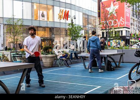 Giovani che giocano a ping-pong o ping-pong su un tavolo da ping pong pubblico a Manhattan, New York Foto Stock