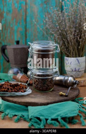 Composizione rustica del caffè con chicchi macinati, fagioli tostati interi, moka e cialde di anice stellato sfondo verde Foto Stock