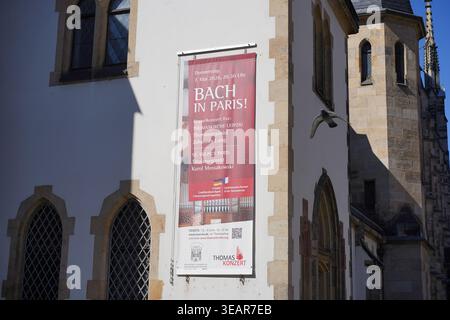 Lipsia, Germania - 23 aprile 2026: Un grande striscione sulla chiesa di San Tommaso che pubblicizza il concerto "Bach in Paris" con l'organista Johannes Lang. Foto Stock
