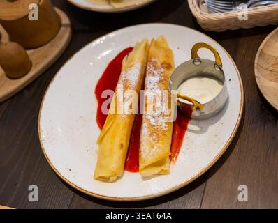 Il dessert nel ristorante è costituito da due pancake arrotolati, ripieni di cagliata Foto Stock