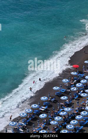 Ombrelloni e onde a Spiaggia grande a Positano, Costiera Amalfitana, Italia Foto Stock
