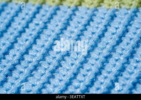 Maglia in maglia di colore blu con striscia verde, che mostra dettagli di cuciture macro e superficie in materiale sintetico. Concetto di maglieria pratica Foto Stock