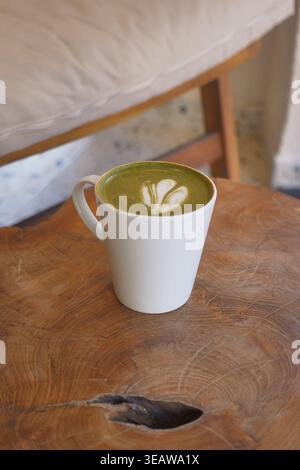Gustatevi una calda tazza di matcha in un intimo tavolo da caffe' Foto Stock
